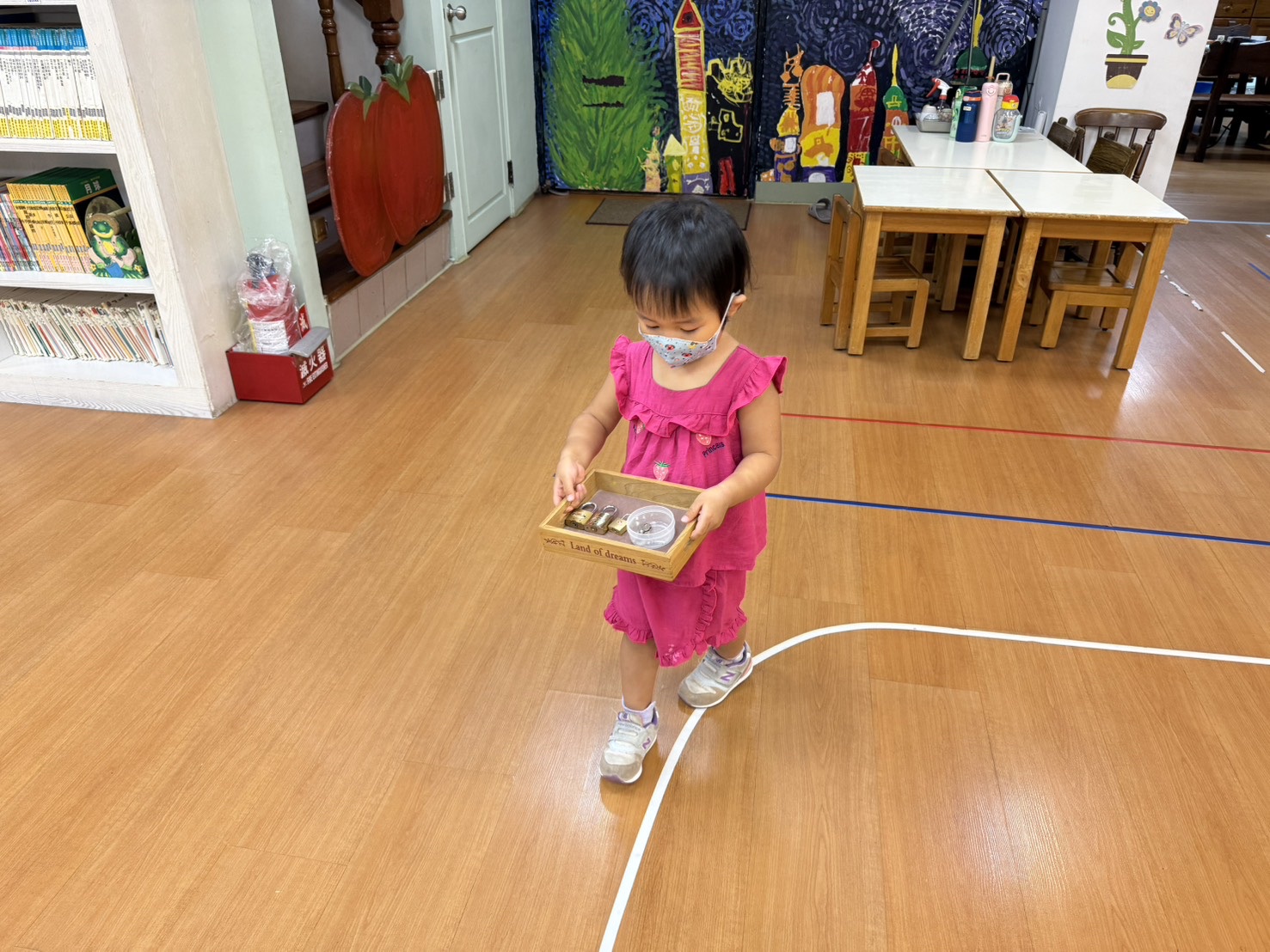 孩子手持托盤沿著地面線條行走